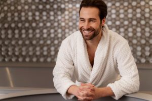 Homem moderno praticando autocuidado inteligente através do Wellness Masculino: Massagens relaxantes para aliviar tensões do dia a dia; Cuidados com a pele para manter aparência saudável; Momentos de relaxamento para reduzir o estresse; Tratamentos corporais que promovem equilíbrio e bem-estar.